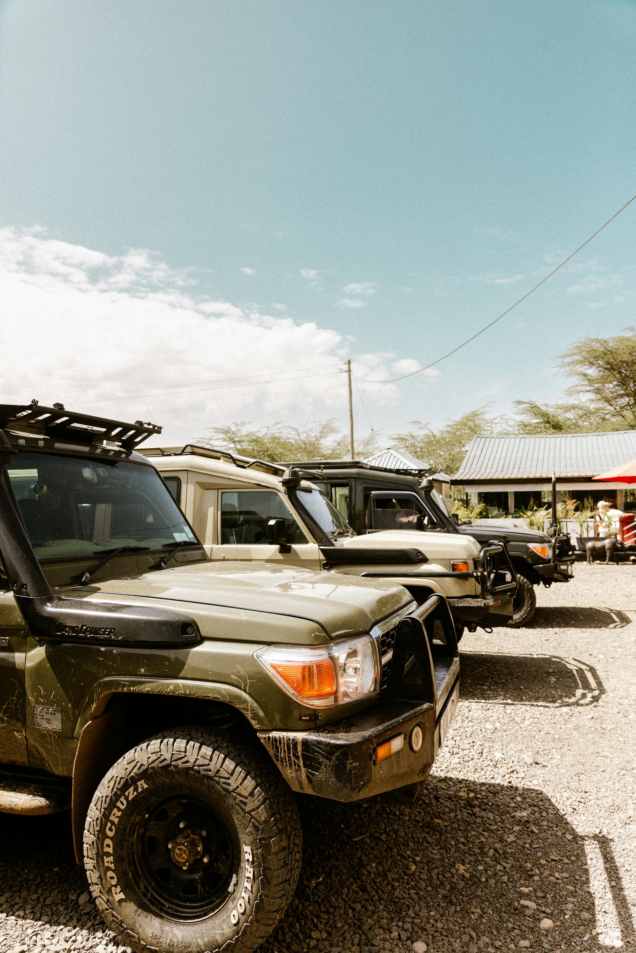 Row of parked safari vehicles under a clear blue sky, ready for adventure.