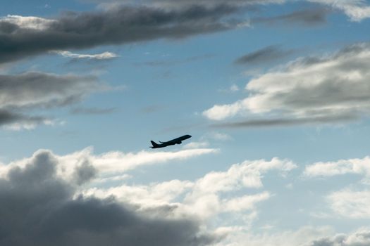 A jet airplane silhouetted against a cloudy sky, capturing the essence of travel and freedom.