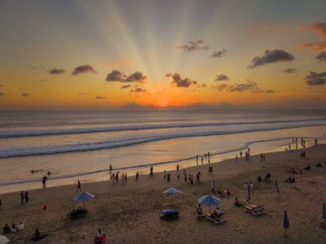 Mesmerizing sunset over a lively Bali beach, perfect vacation backdrop.