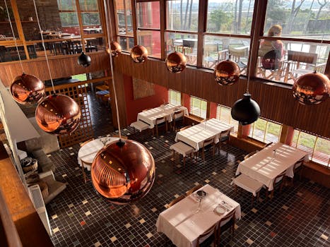 Elegant dining area with copper lights and large windows, located in Fão, Portugal.