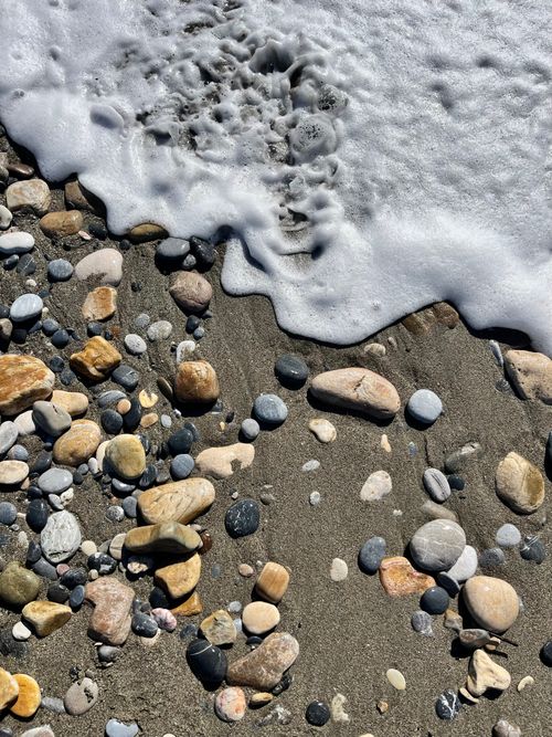 Free A picturesque capture of pebbles and ocean waves on a Mediterranean beach in Turkey. Stock Photo