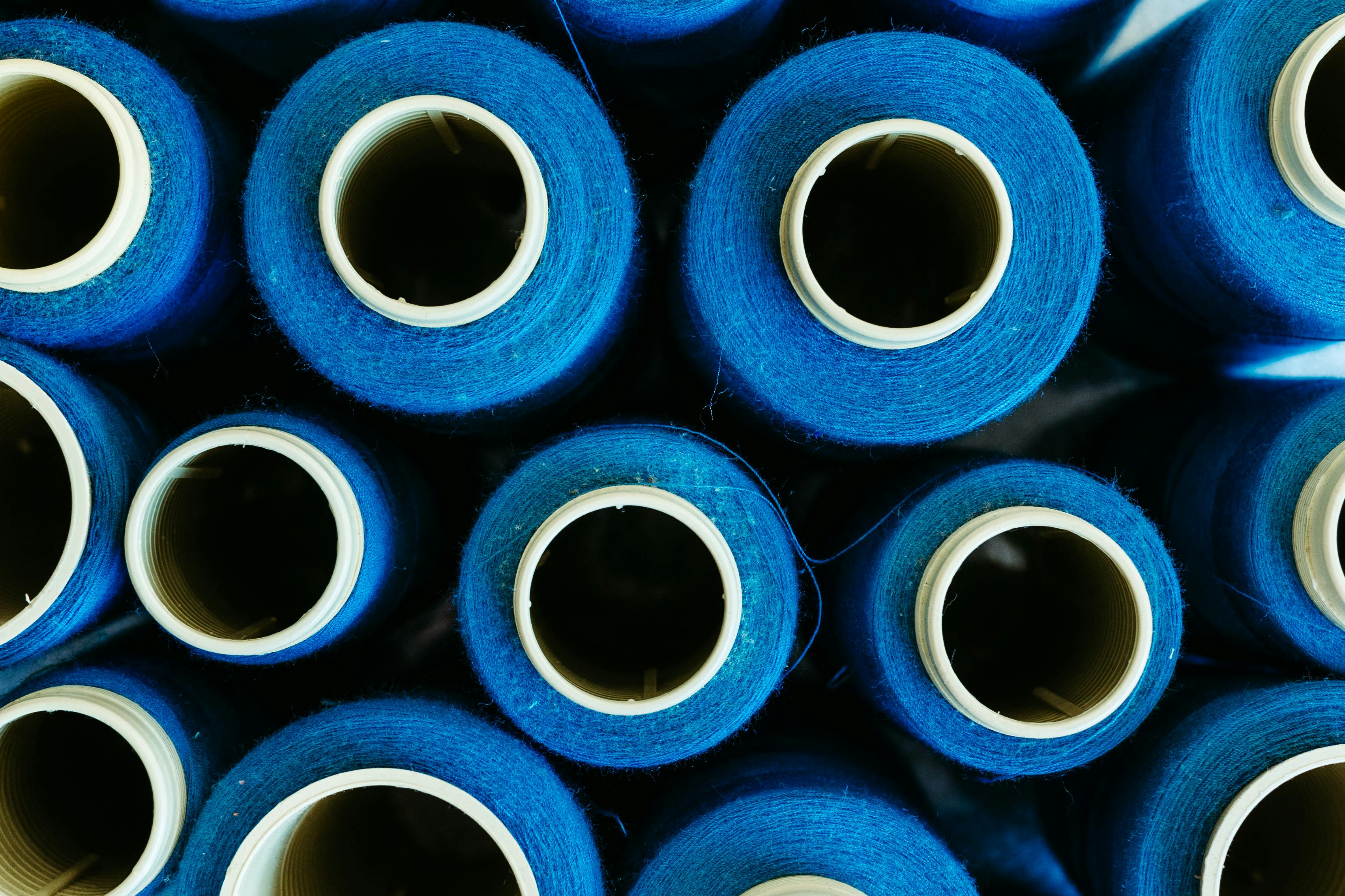 無料 カラフルな青い繊維スプールが上面図にきちんと並べられており、産業と製造資材を紹介しています。 写真素材