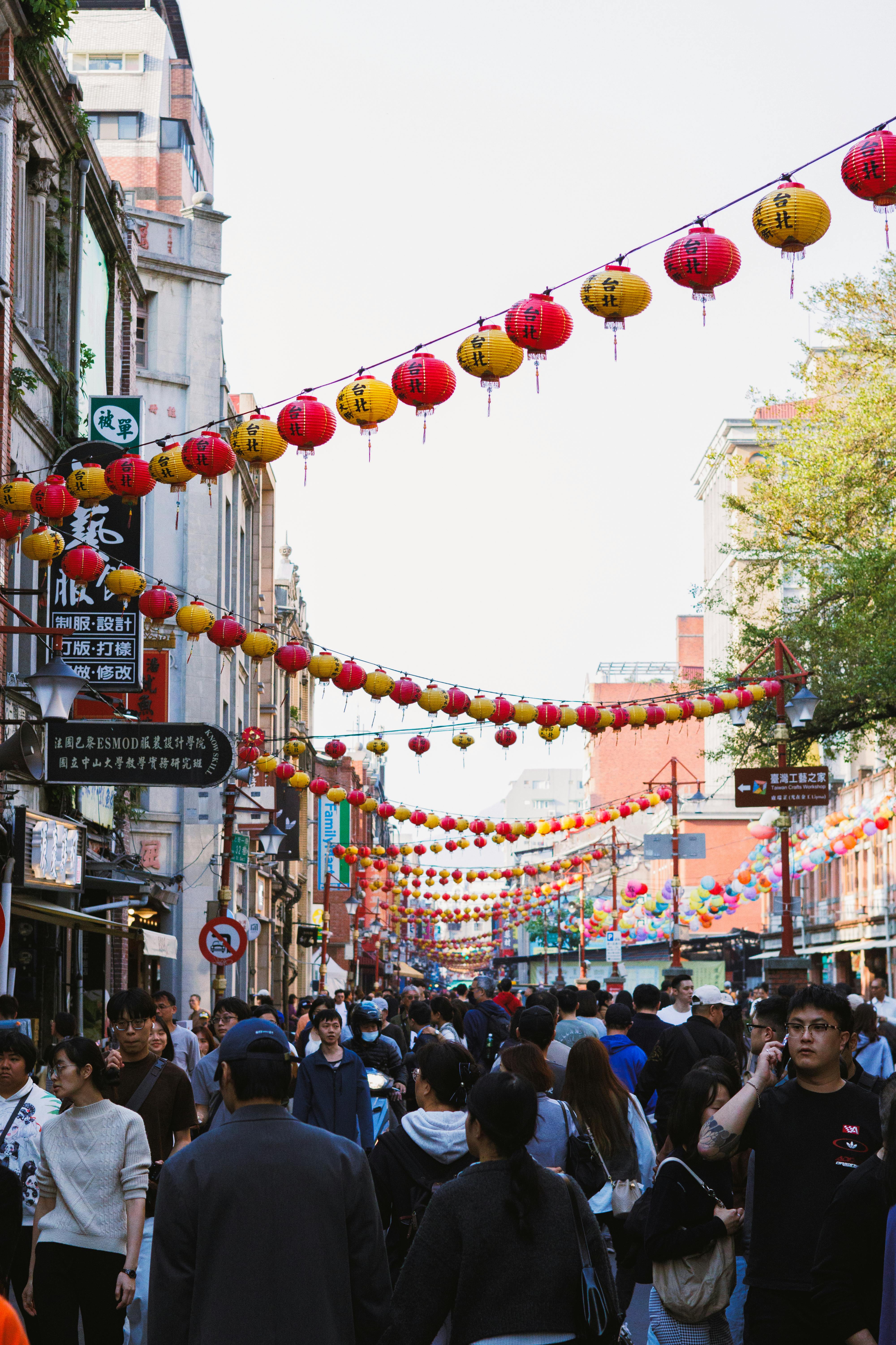 Gratis Folkfull gatescene i Chinatown med livlige røde og gule lykter over hodet, som fanger opp bylivet og kulturfeiringen. Arkivbilde