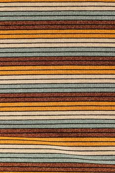 Close-up of a multicolored striped fabric with earthy tones, perfect for design use.