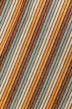 Vibrant close-up of a diagonal striped textile pattern in warm tones.