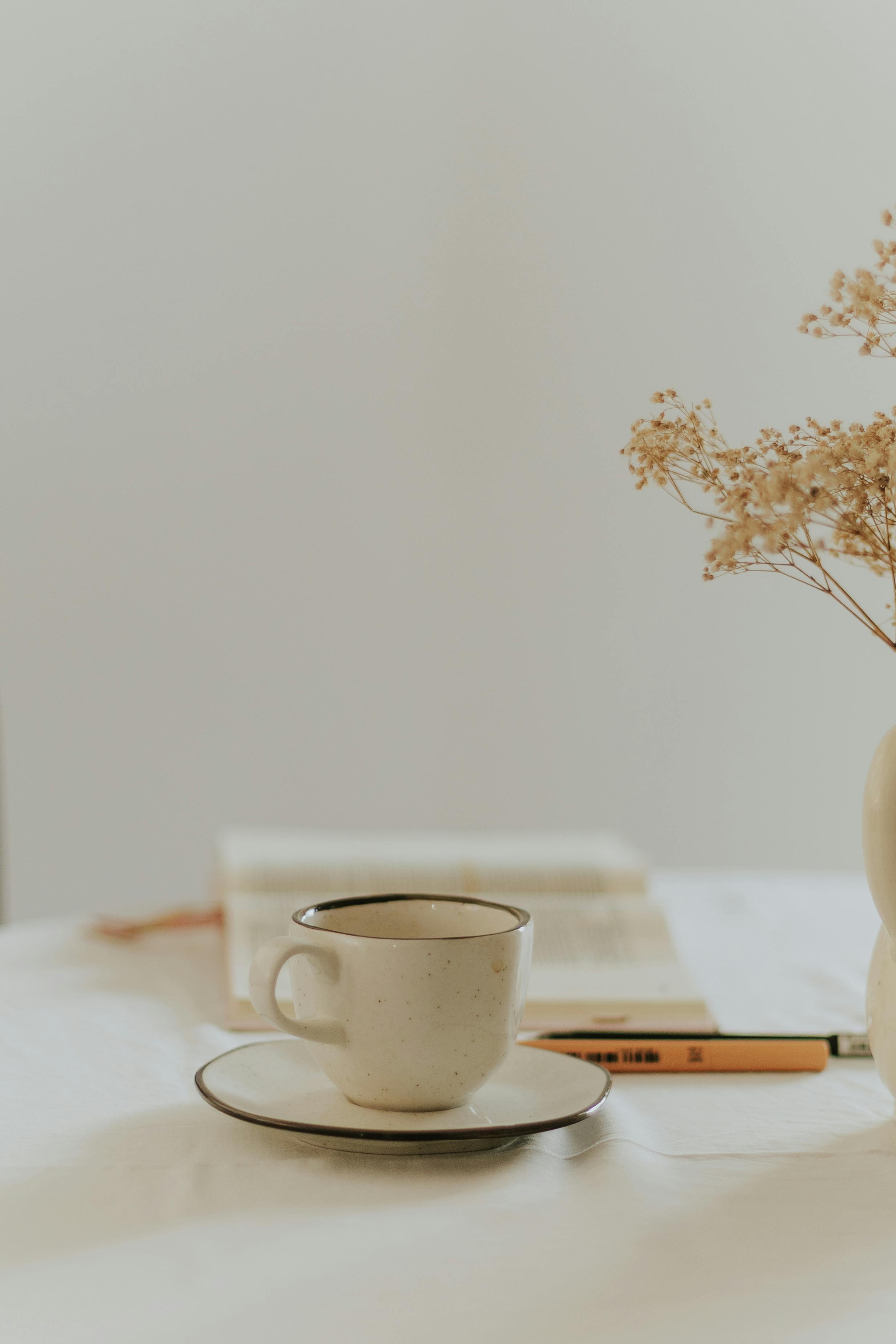 Free A minimalist coffee cup and dried flowers on a cozy table setting. Stock Photo