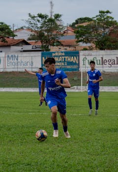 Young soccer players in action during an outdoor match on a green field.
