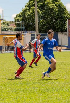 Players compete in a lively outdoor soccer game on a sunny day.