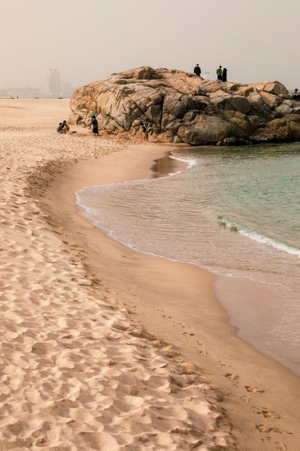 Serene beach landscape featuring sandy shores and rock formations, ideal for relaxation.