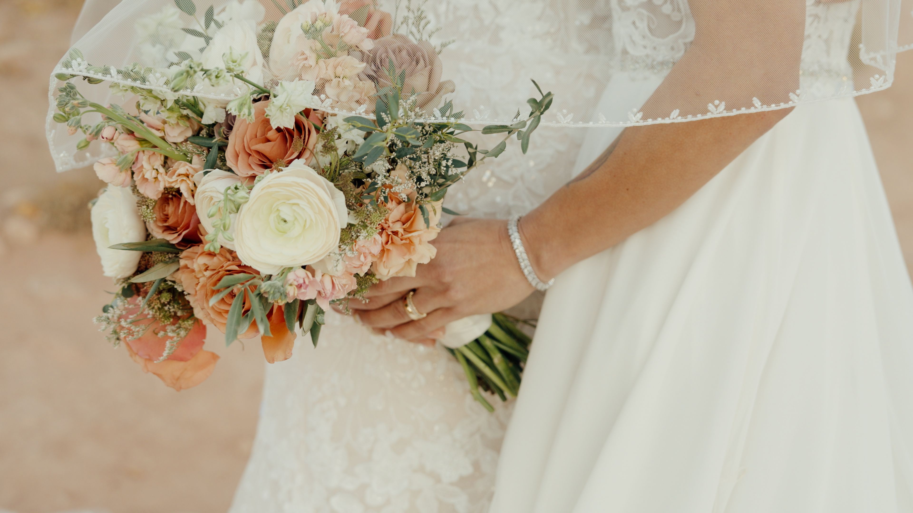 Beautiful bridal bouquet with roses and eucalyptus in a desert wedding setting.