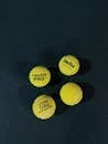 Four Tennis Balls on a Dark Court Surface