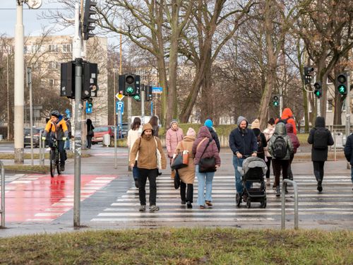 Free A lively city crosswalk with diverse pedestrians and cyclists on a winter day. Stock Photo