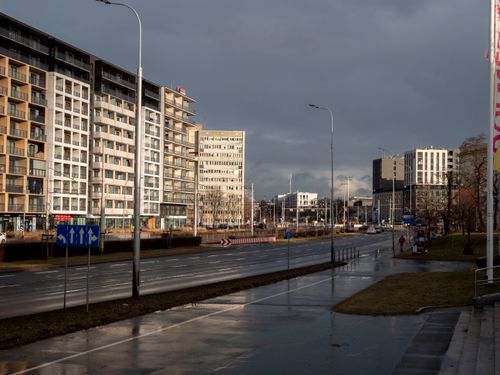 Free Empty city street with modern apartment buildings under a cloudy sky. Stock Photo