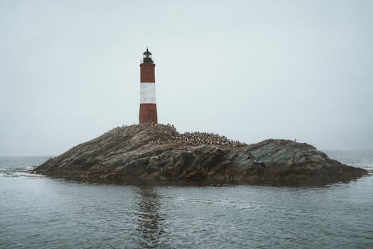 Scenic view of Faro Les Eclaireurs lighthouse on rocky island in Ushuaia, Argentina.