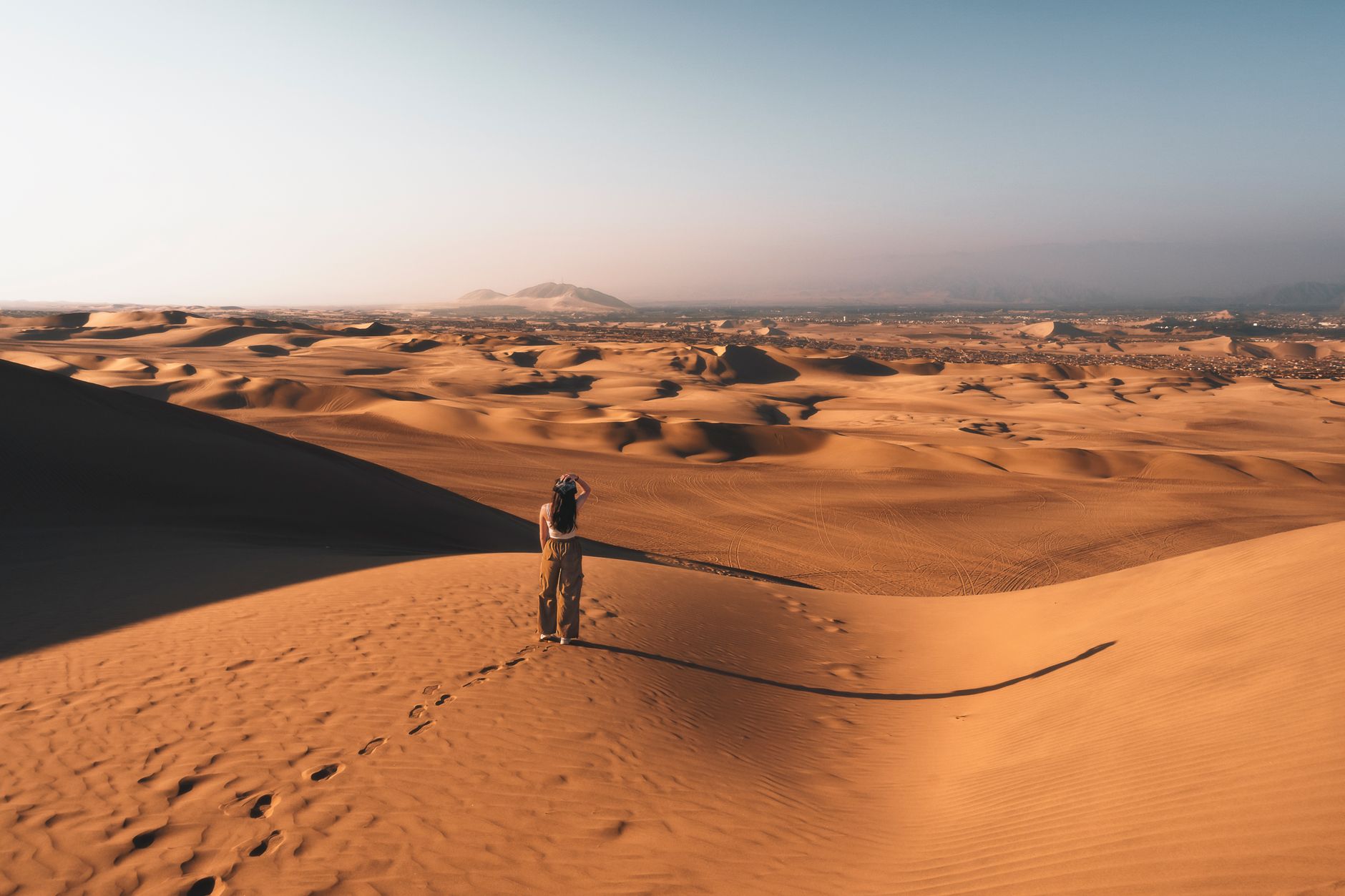 Explore the stunning desert scenery at Huacachina Oasis, Peru during sunset.