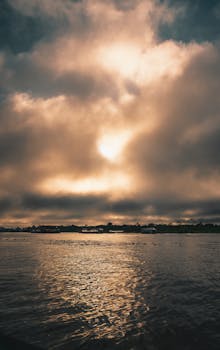 Dramatic sunrise over the Amazon River in Iquitos, Loreto, Peru, creating a warm and serene scene.