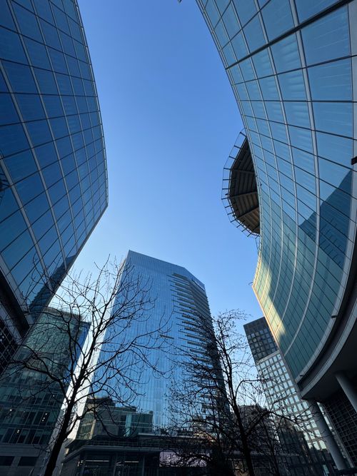 Free Modern skyscrapers with curved glass architecture in Milan under a clear blue sky. Stock Photo