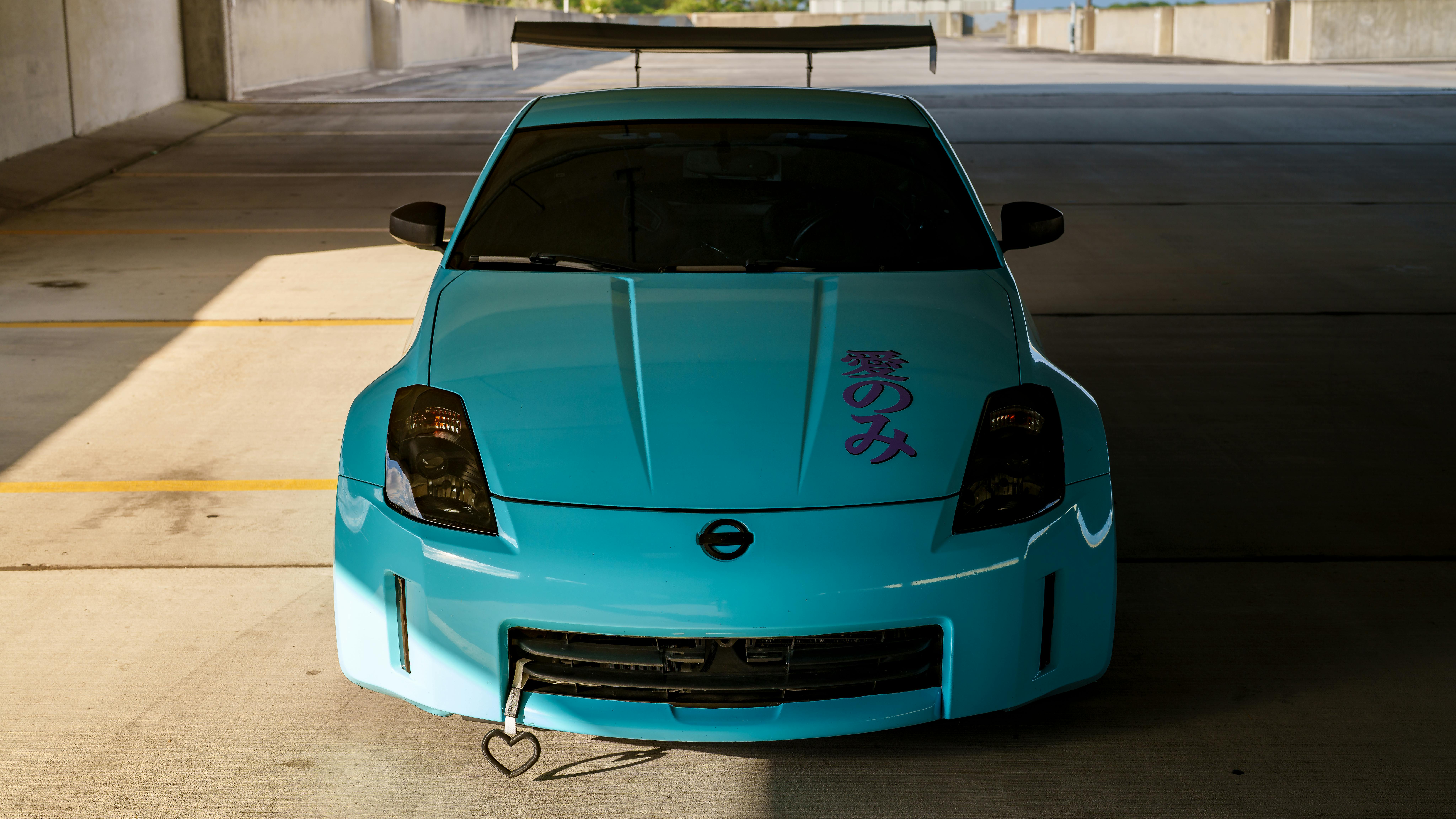 бесплатная Вид спереди на ярко-синий спортивный автомобиль, припаркованный в помещении, с надписью на японском языке. Стоковое фото