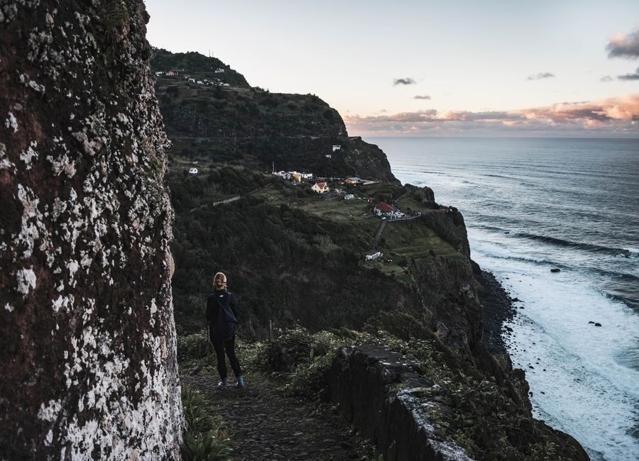 Person walking on a cliffside trail in Madeira, Portugal during the evening.