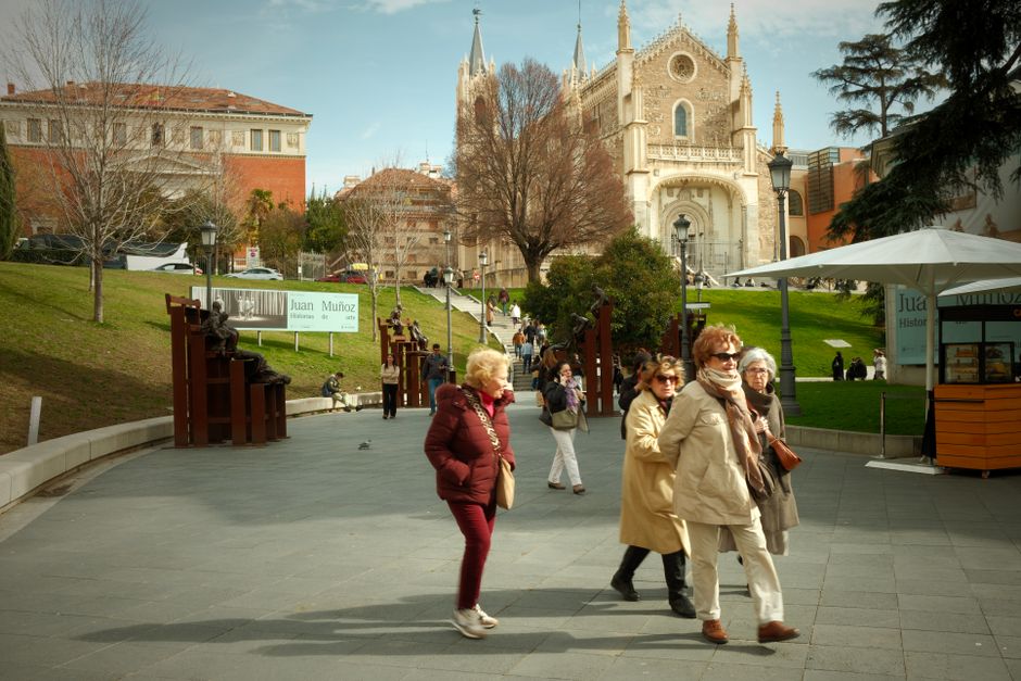 Grupo de adultos caminando cerca de la histórica Iglesia de San Jerónimo el Real en Madrid, España.