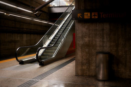 An empty airport terminal with an escalator leading to a terminal. Low light setting.