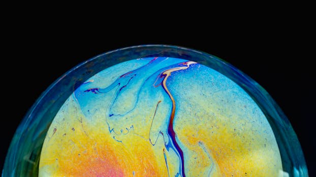 Close-up of a colorful iridescent soap bubble with a black background, showcasing vibrant patterns.