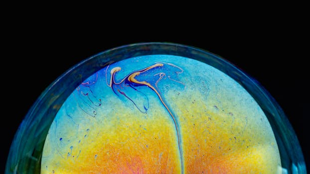 Vibrant iridescent patterns create a stunning abstract sphere on a black background.