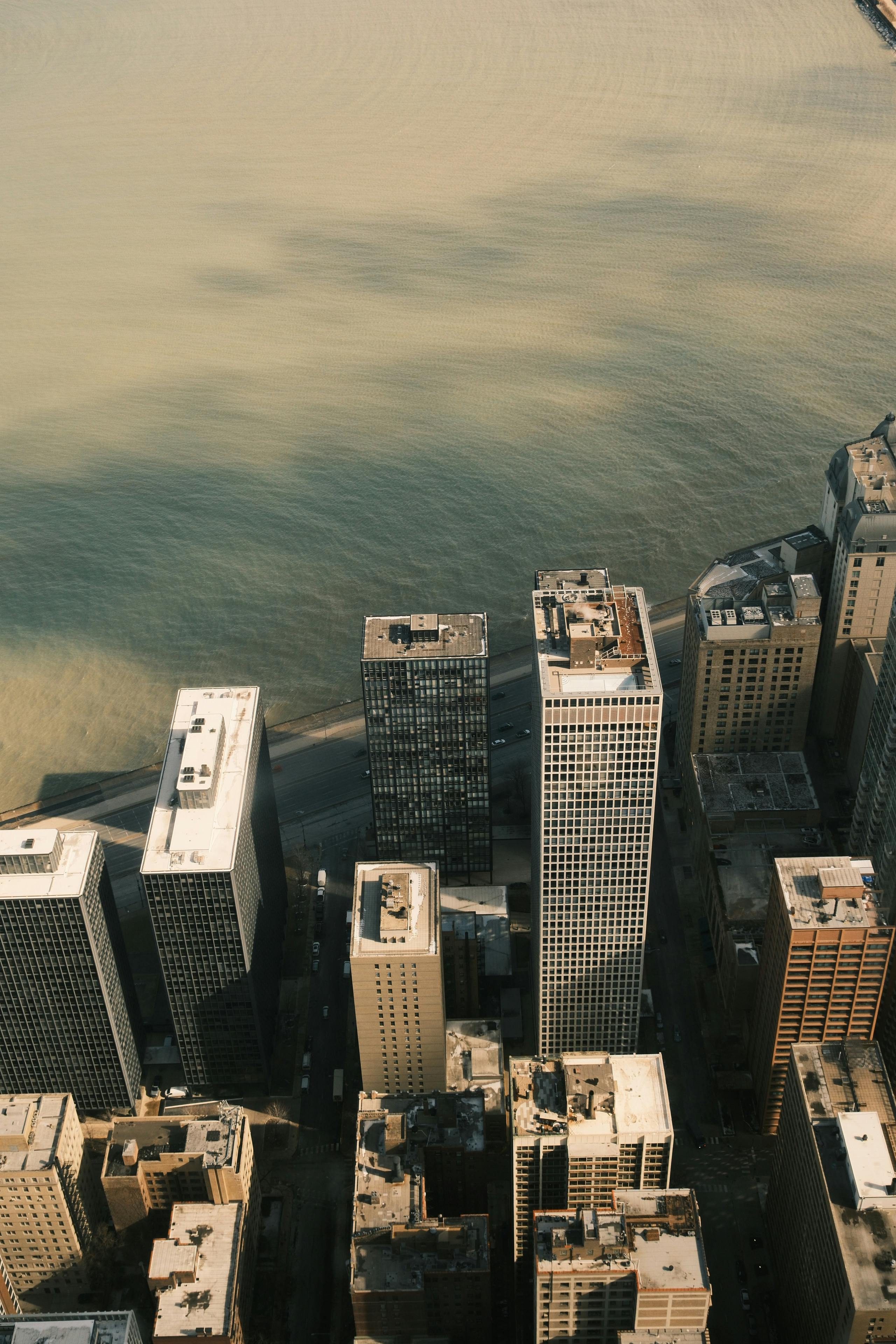 бесплатная Высотные здания, возвышающиеся над рекой, демонстрируют городской пейзаж. Стоковое фото