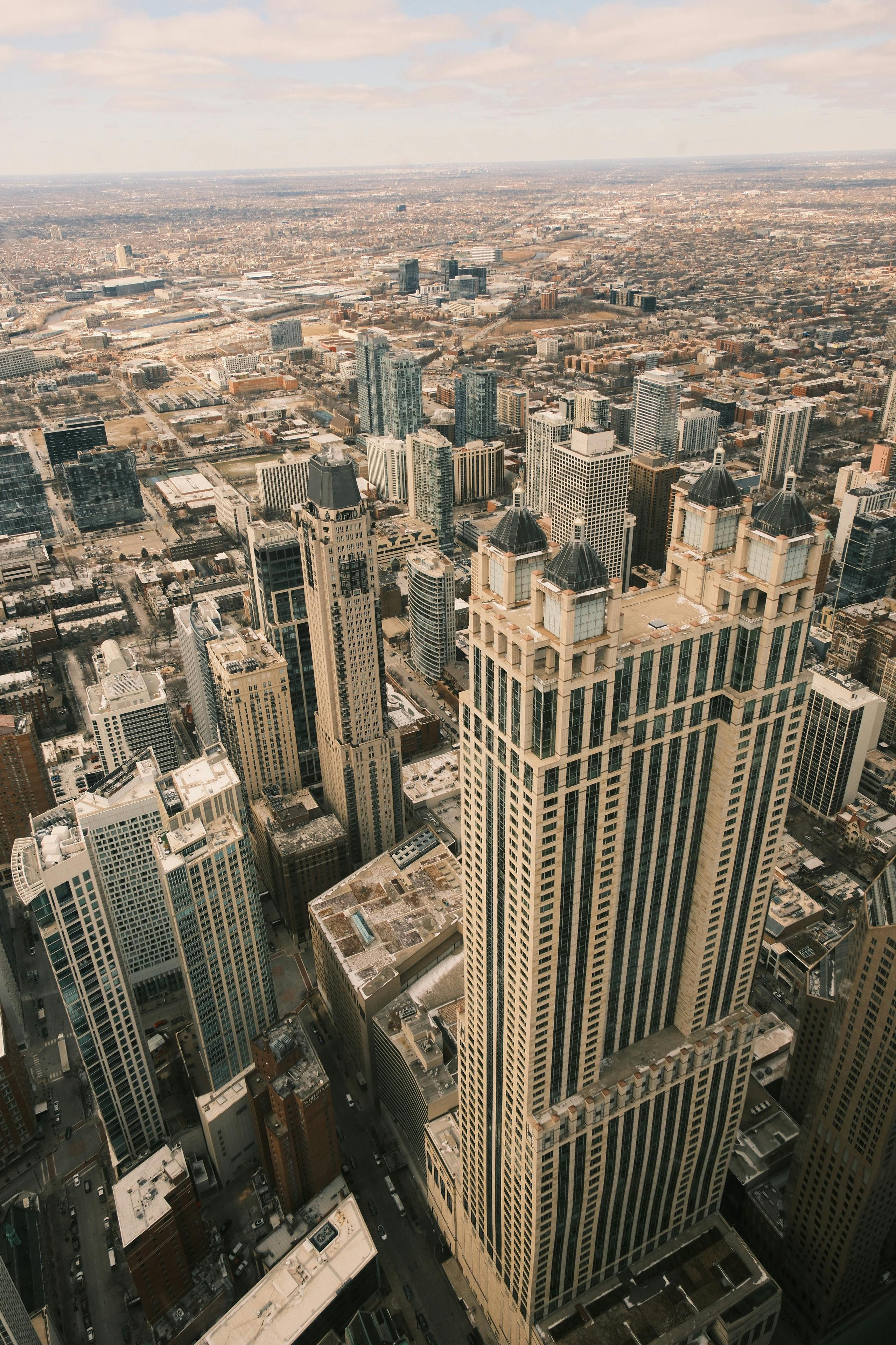бесплатная Вид сверху на культовый силуэт Чикаго, демонстрирующий высокие небоскребы в ясный день. Стоковое фото