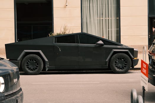 Sleek and futuristic black car parked on a city street near modern building.