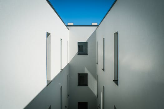 Symmetrical view of a minimalist white building under blue skies in Slovinsko.
