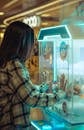 Teen Playing Arcade Claw Machine in Mall