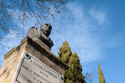 Monument honoring Louis Castagne in Miramas, France with clear blue sky.