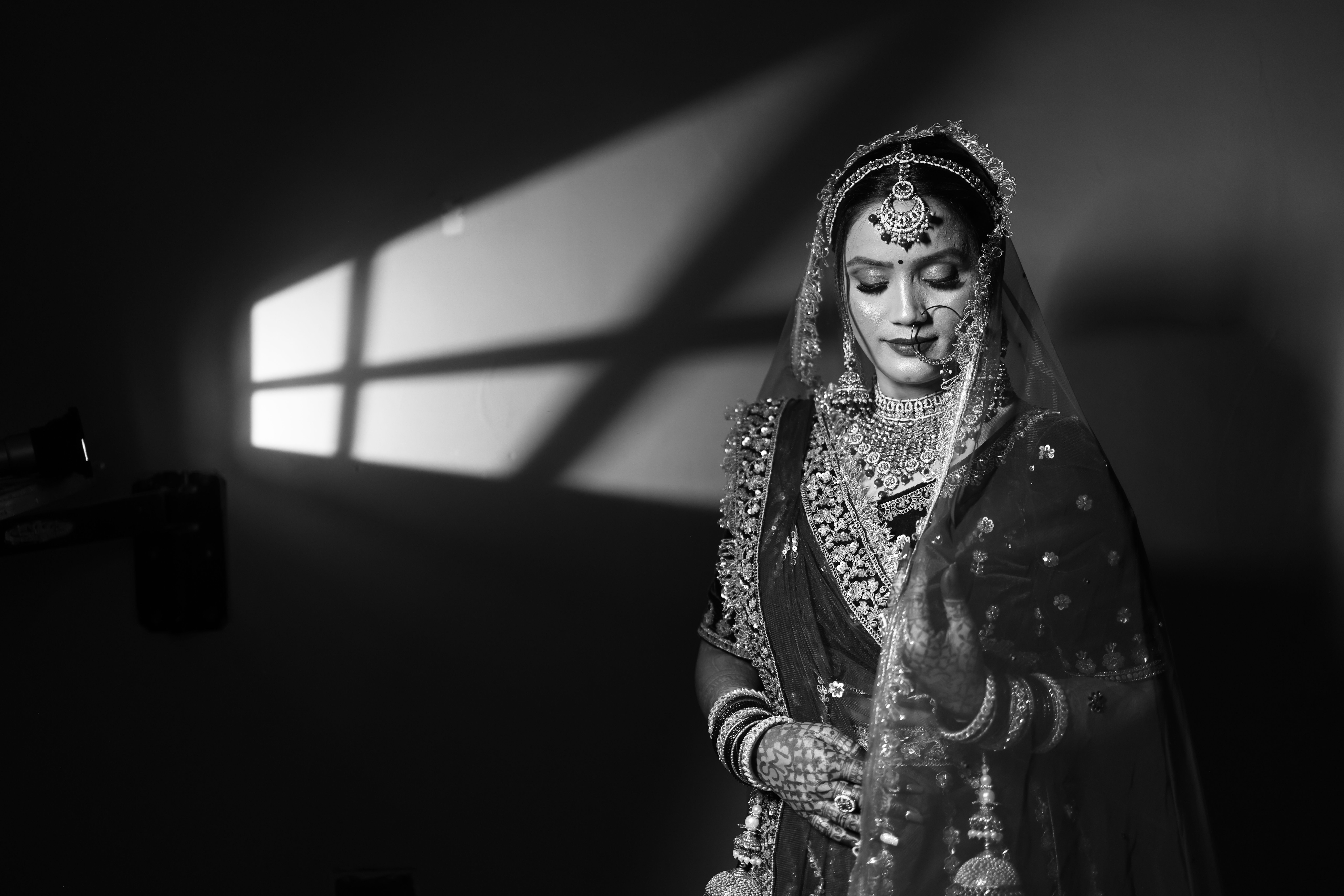 Stunning black and white portrait of a traditional bride adorned with intricate jewelry.