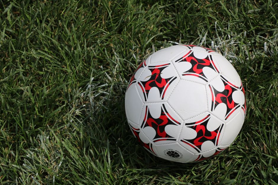 Detailed shot of a soccer ball with unique pattern on green grass. Ideal for sports themes.