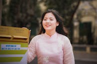 Smiling Woman in Traditional Ao Dai by Mailbox