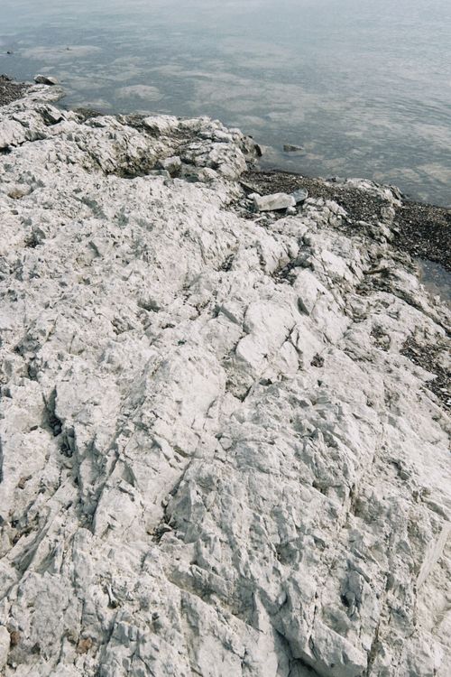 Free White rocky shoreline and tranquil waters in Konaev, Kazakhstan create a serene natural scene. Stock Photo
