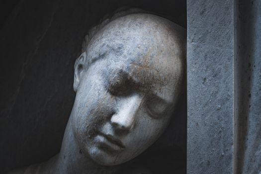 A detailed close-up of a serene stone sculpture head depicting tranquility and timeless beauty.