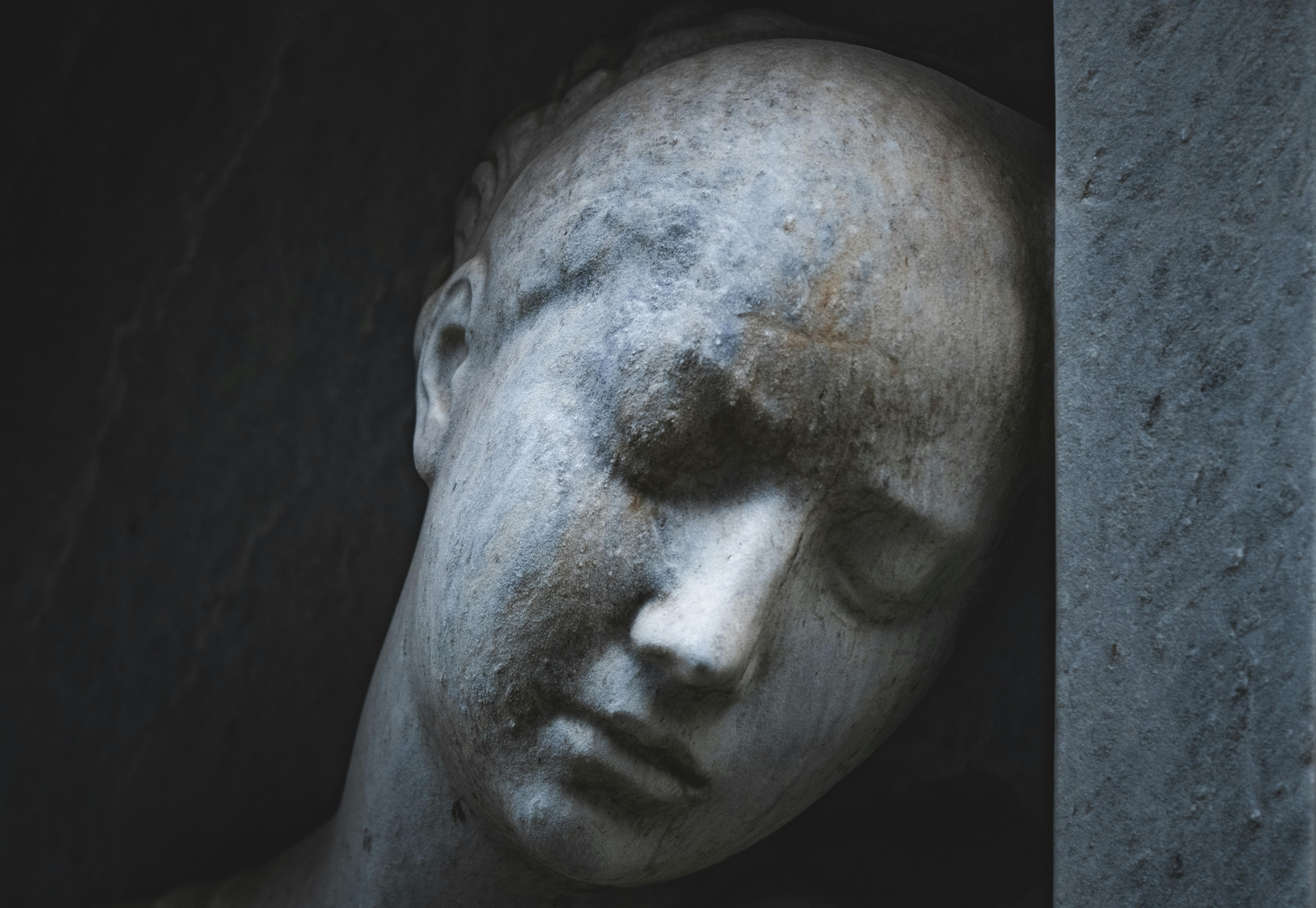 De franc Una escultura de cap de marbre serè amb els ulls tancats capturada amb poca llum, que expressa tranquil·litat. Foto d'estoc