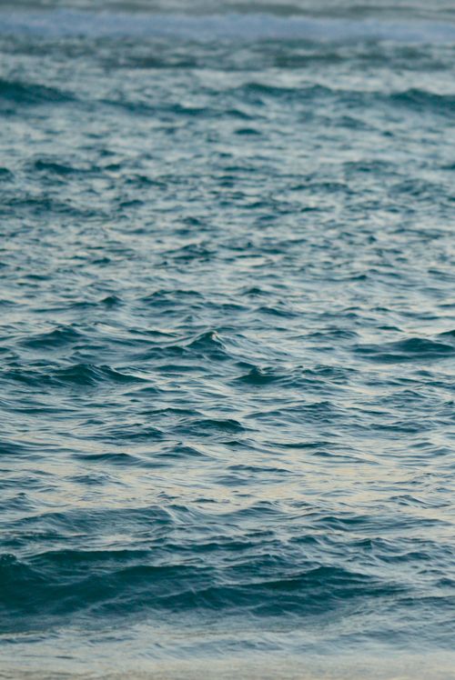 Free Capture of serene ocean waves rolling gently at dusk, conveying peace and tranquility. Stock Photo