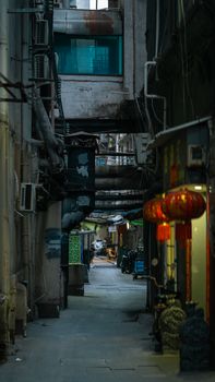 Dramatic urban alleyway featuring red Chinese lanterns and industrial architecture.