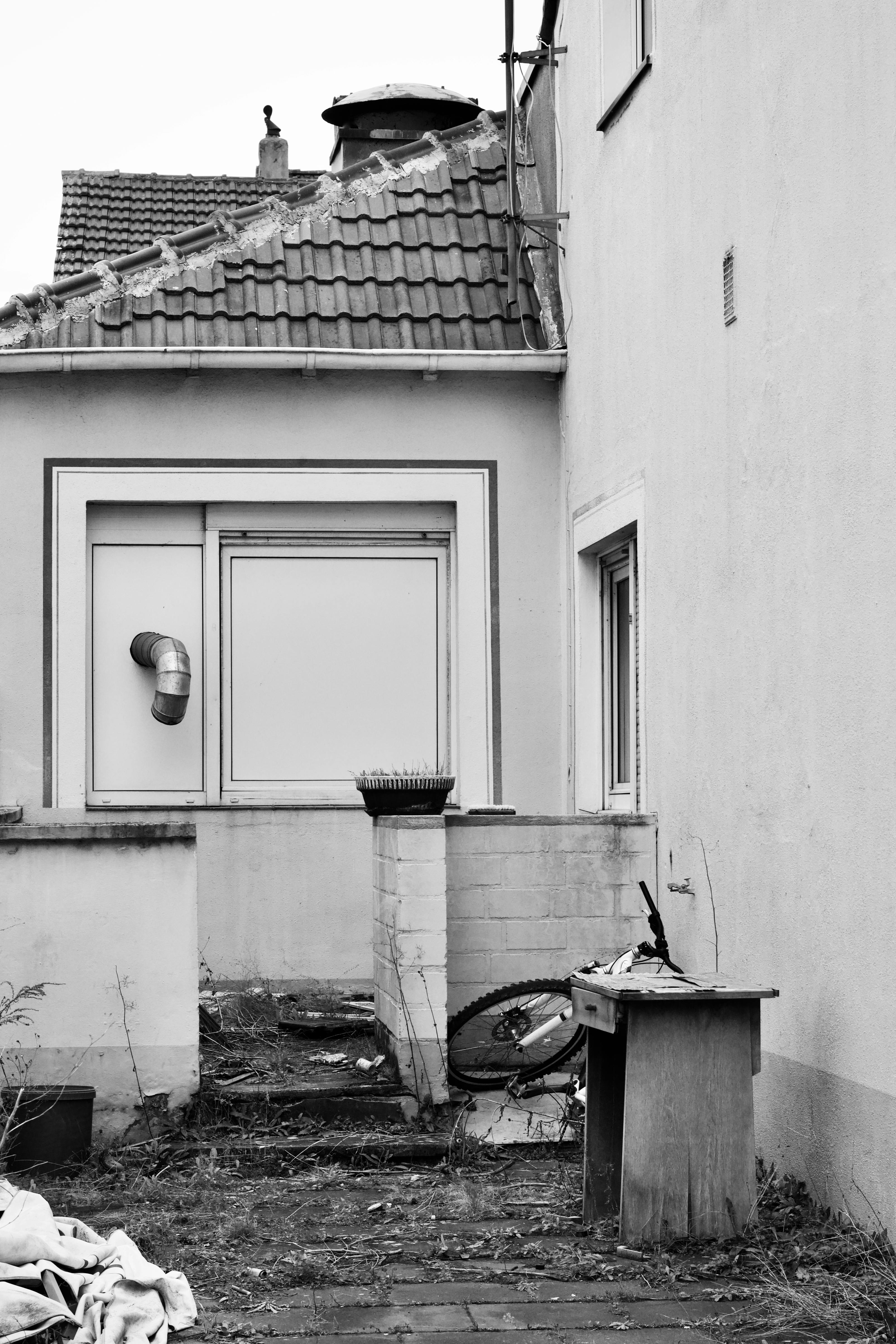 бесплатная Черно-белая фотография городского двора со старыми постройками и мусором. Стоковое фото