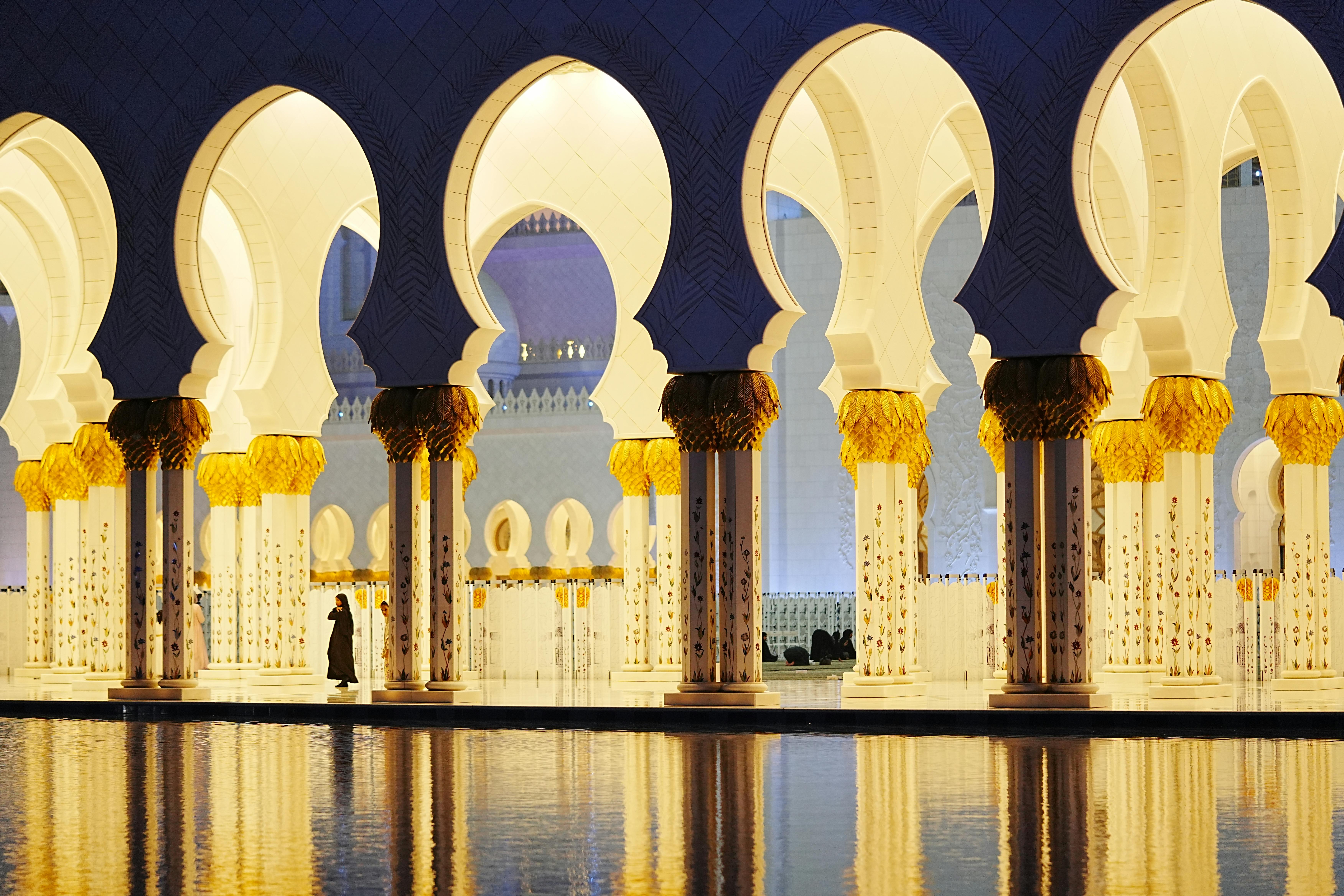 Stunning view of Sheikh Zayed Grand Mosque's arches at twilight with reflections in Abu Dhabi.