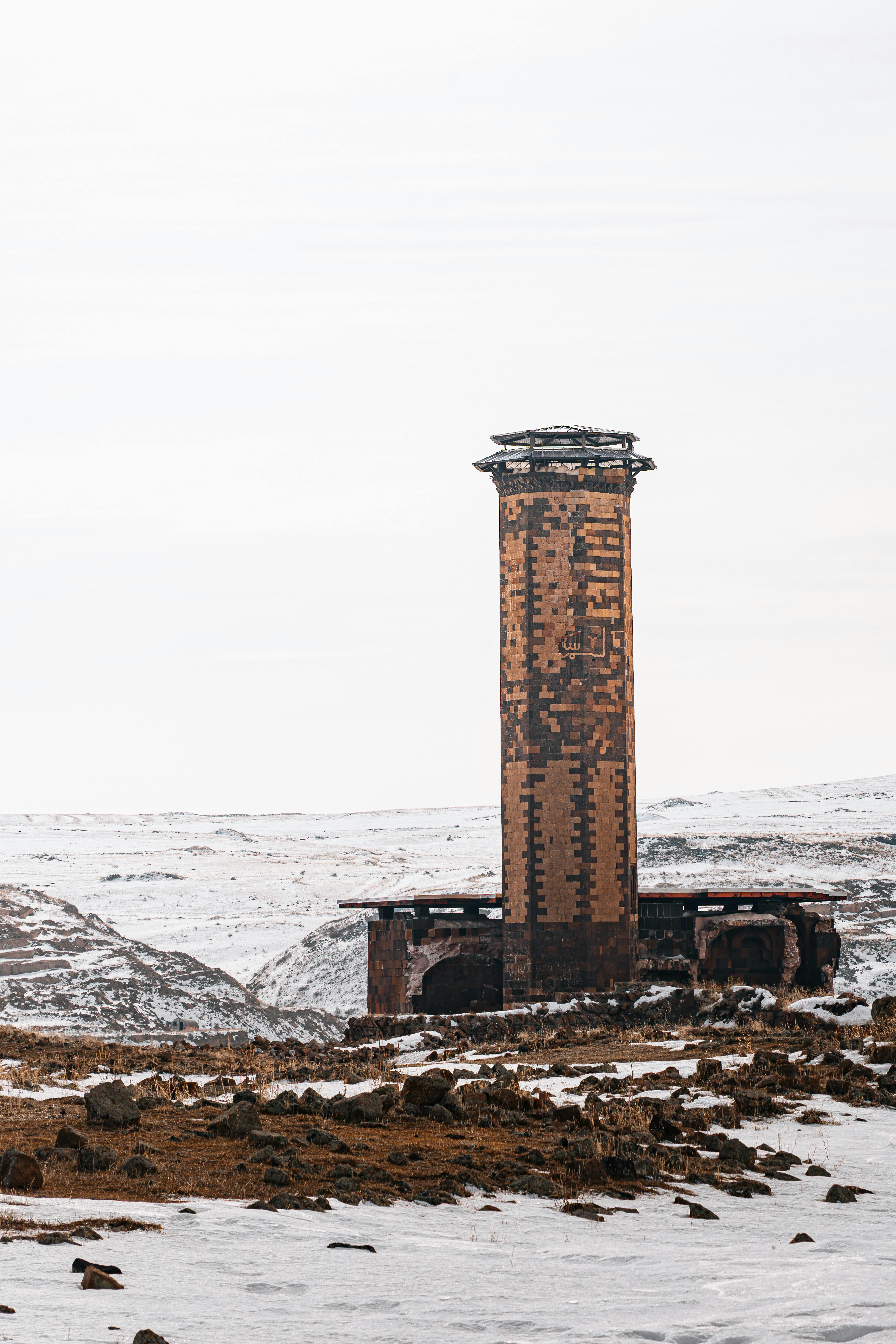 無料 トルコ、カルスの雪景色の中に佇む、歴史的建築物を代表する古代のミナレット。 写真素材