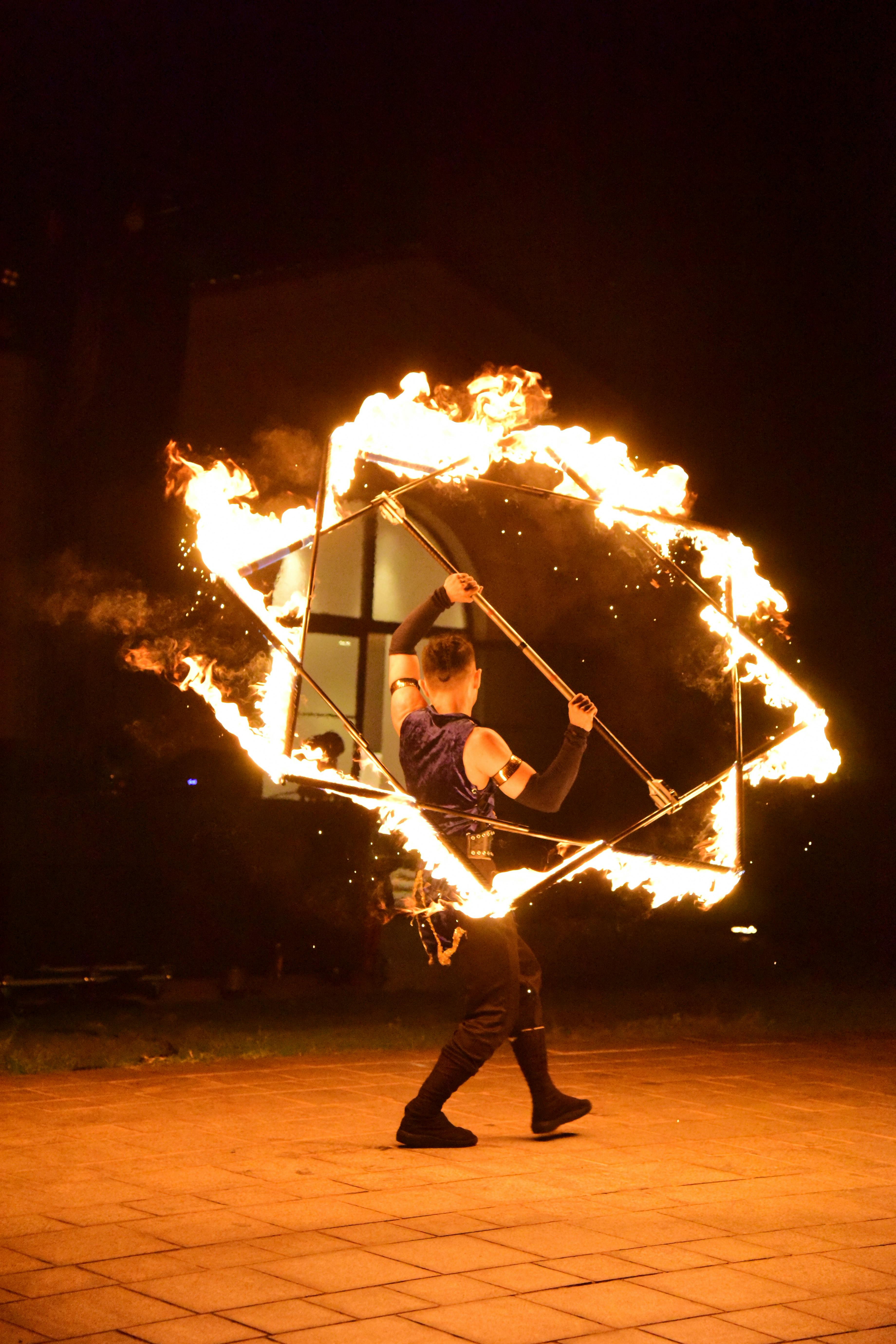 A captivating night fire performance by a skilled acrobat using a flaming cube.