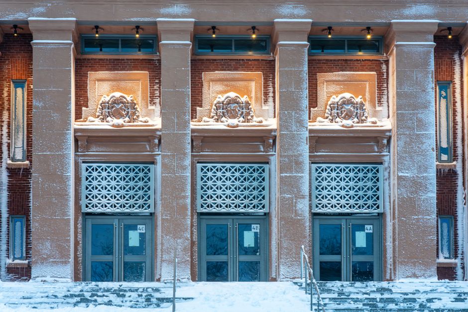 Snow-covered entrance of a historic building in Somerville, Massachusetts, evening.