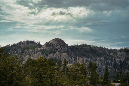 Free Dramatic landscape of the Black Hills with rocky mountains and lush forests under cloudy skies. Stock Photo