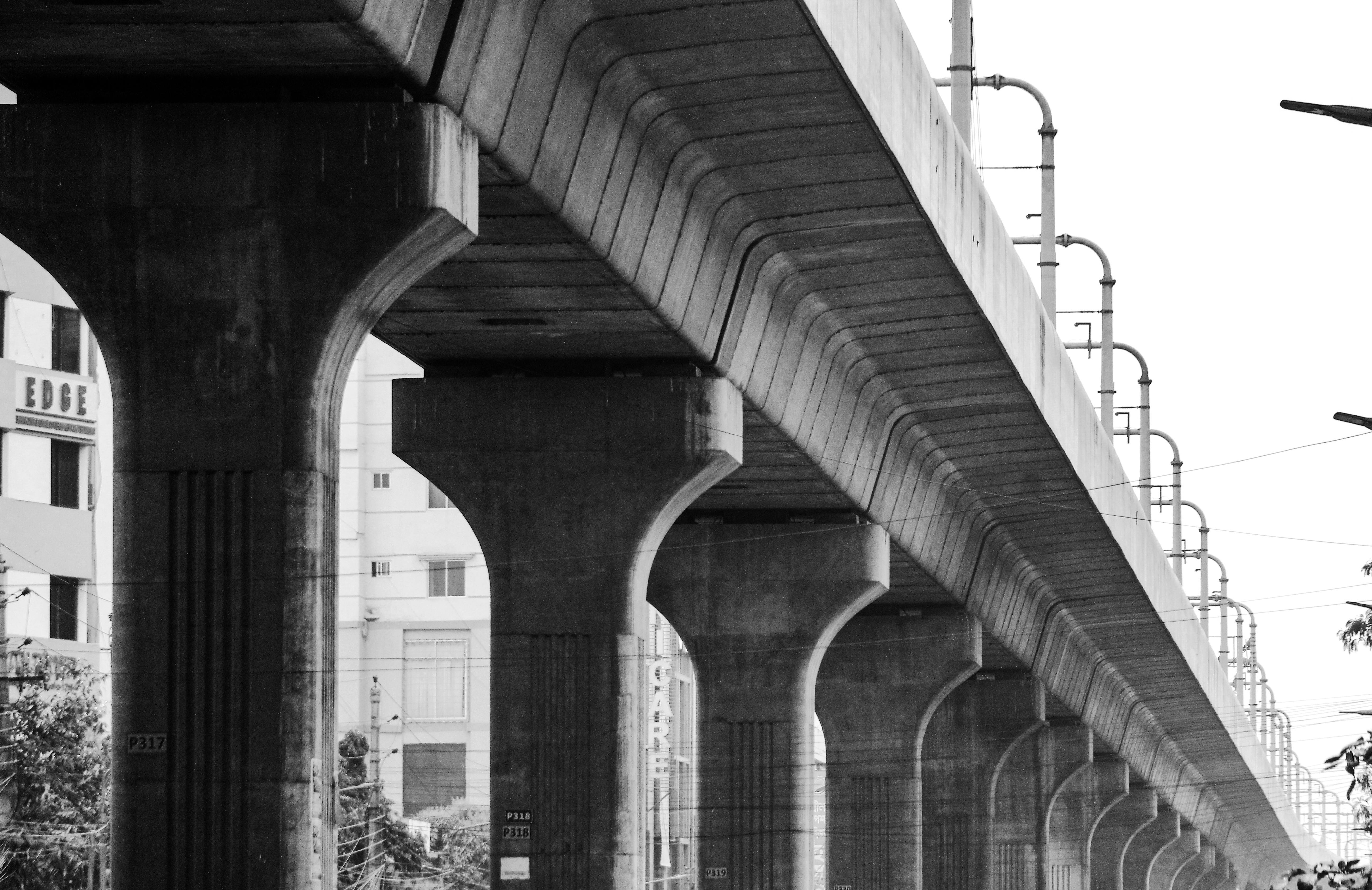 無料 都市環境におけるコンクリート高架橋の白黒画像。構造設計が示されています。 写真素材