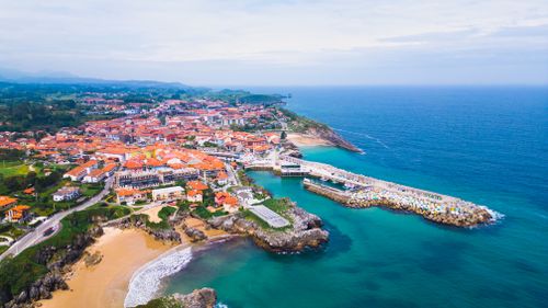 Free A breathtaking aerial view of Llanes, Spain, showcasing its vibrant coastline and historic architecture. Stock Photo