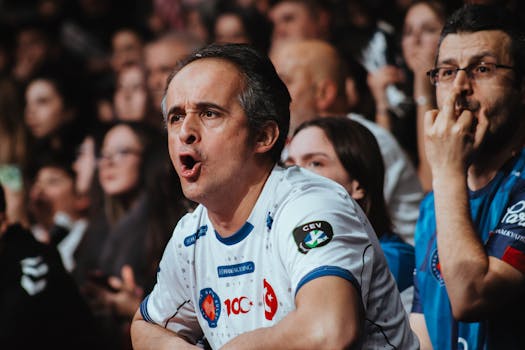 Passionate fans in a crowd showing excitement at a sports event. Engaging atmosphere and team spirit.